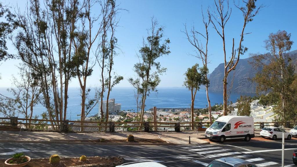 a white van parked in a parking lot with a view of the ocean at Casa Mina in Puerto de Santiago