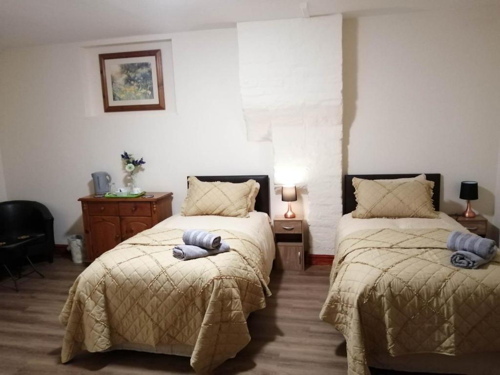 1 dormitorio con 2 camas con almohadas en The Old Cart Shed en Lenwade