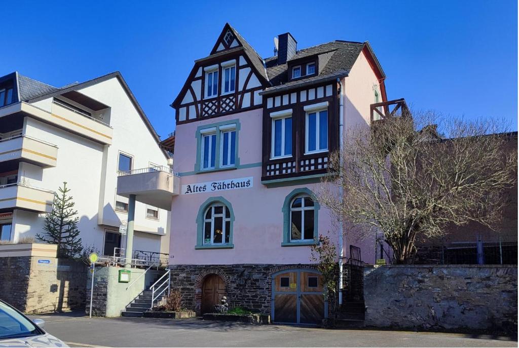 ein weißes und schwarzes Gebäude mit einer Acrim-Kammer darauf in der Unterkunft Gästehaus im Alten Fährhaus in Cochem