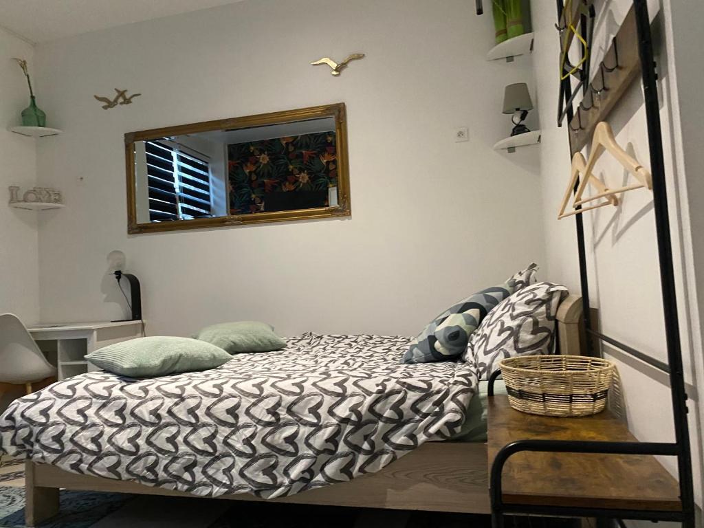 - une chambre avec un lit avec un miroir et une table dans l'établissement Le petit studio à découvrir..., à Marquette-lès-Lille