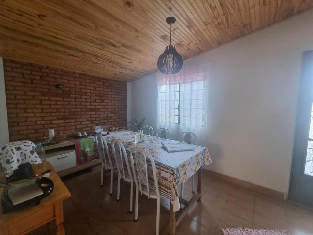 uma sala de jantar com mesa e cadeiras em Casa para Aluguel de Temporada - Carrancas MG em Carrancas