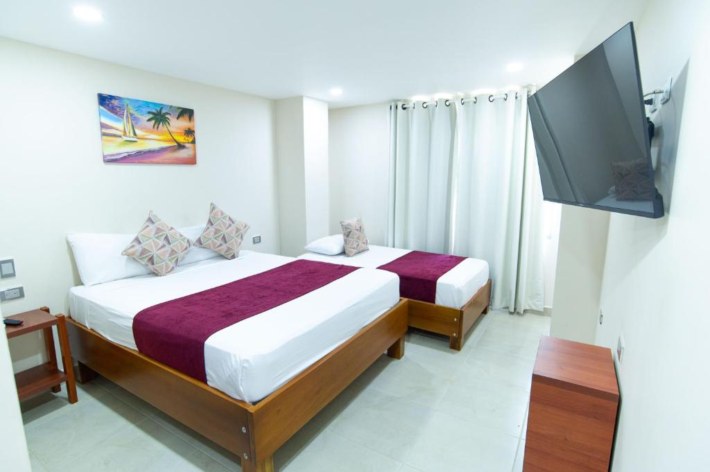 a bedroom with a bed and a flat screen tv at Hotel Sierra Nevada in Santa Marta