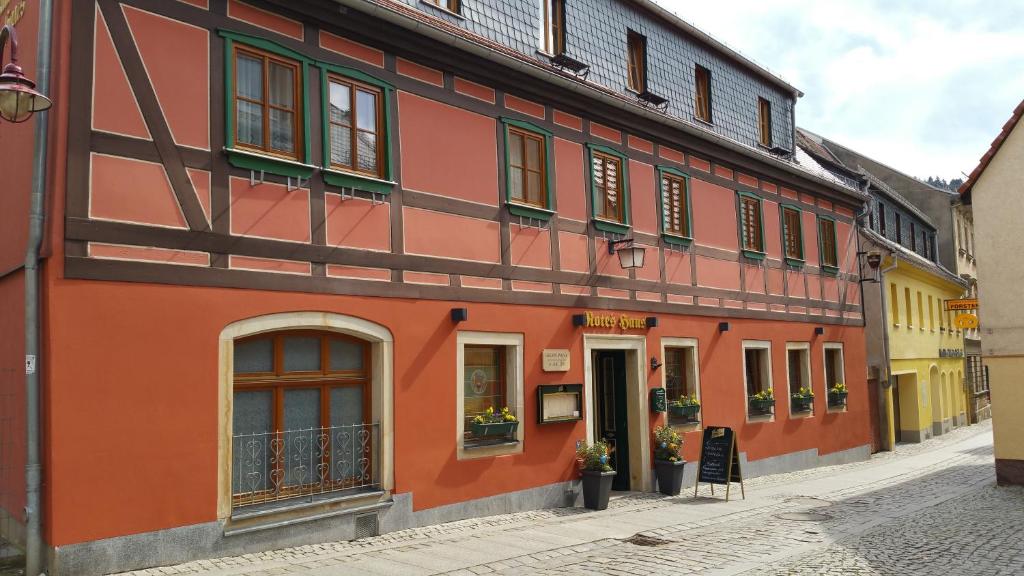 um edifício laranja ao lado de uma rua em Gasthaus& Pension Zum Roten Haus em Bad Schandau