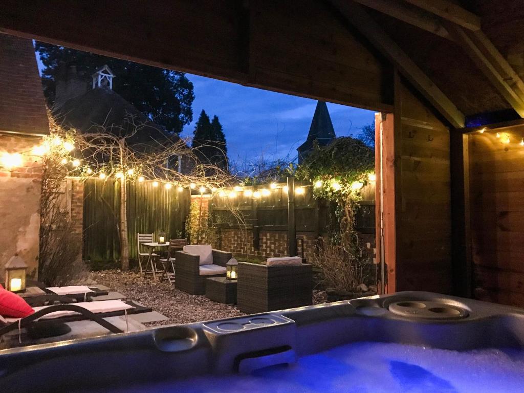 a jacuzzi tub in a backyard at night at Old Rectory Cottage in Fernhurst