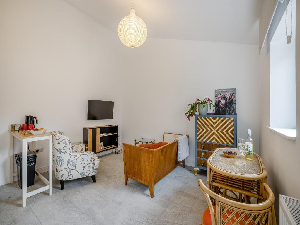 ein Wohnzimmer mit einem Tisch und Stühlen sowie einem TV in der Unterkunft Angeliki - Uk43588 in Ellesmere
