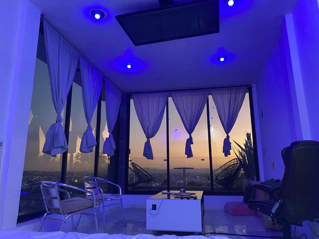 Cette chambre violette comprend des chaises et une grande fenêtre. dans l'établissement Loft en Tercer Piso con Vista Panoramica, à Puebla