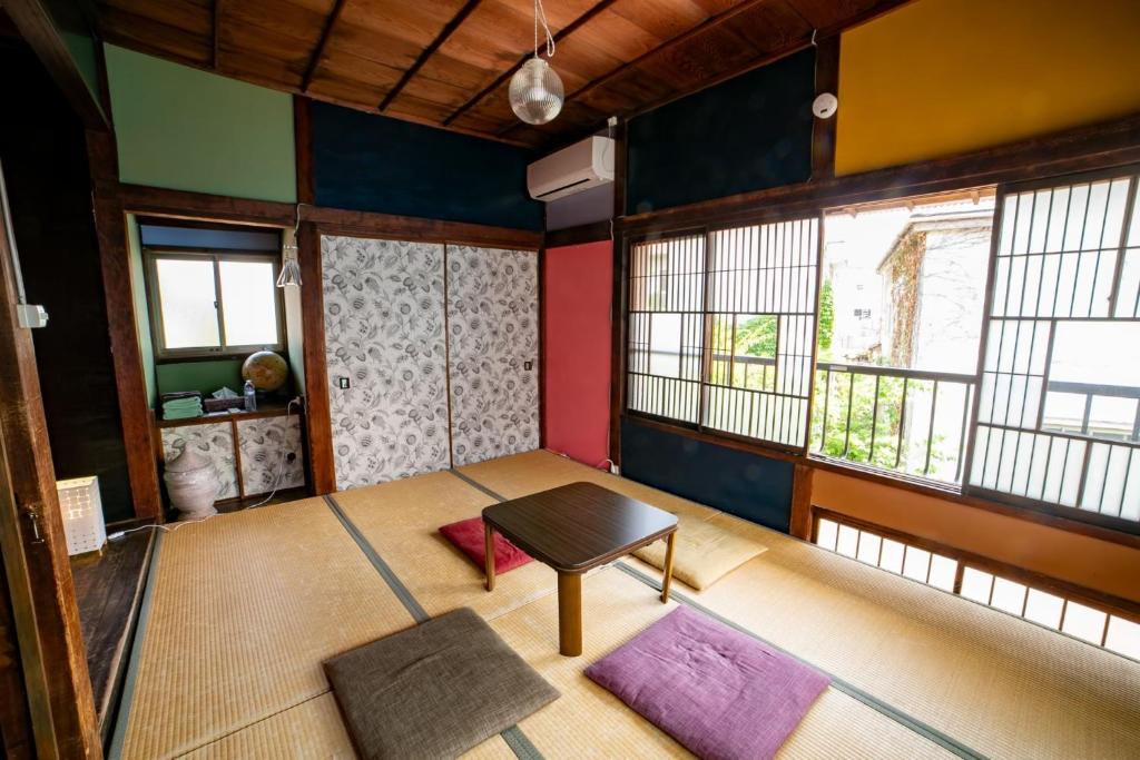 une pièce vide avec une table et quelques fenêtres dans l'établissement Villa Sacra ヴィラサクラ, à Kamakura