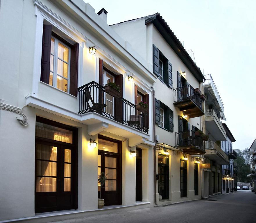 a white building with windows and balconies on a street at Isioni Pension in Nafplio