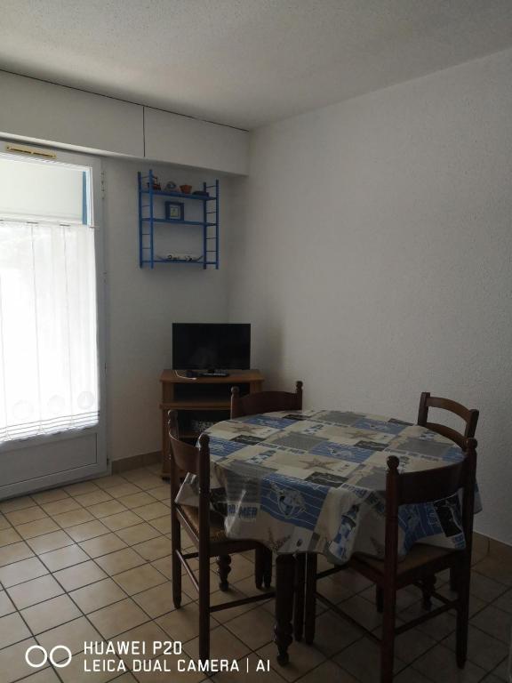une salle à manger avec une table, des chaises et une télévision dans l'établissement LES OCEANIDES, à Bretignolles-sur-Mer