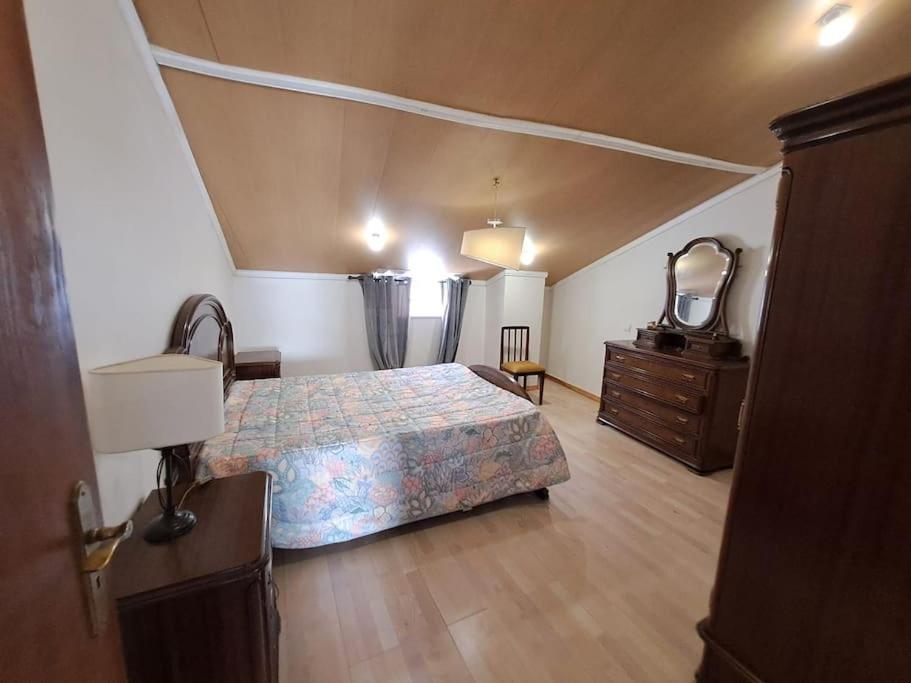 um quarto com uma cama, uma cómoda e um espelho em Vivenda do Américo em Juncal