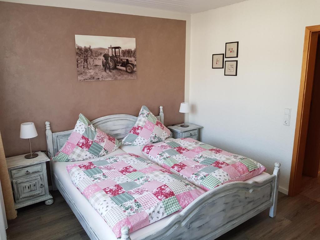 ein Bett mit einer Decke und Kissen in einem Schlafzimmer in der Unterkunft Gästehaus Vinum Doppelzimmer in Leiwen