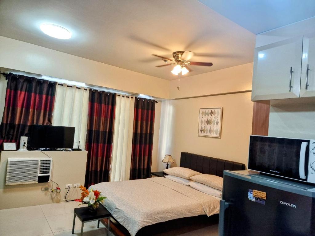 um quarto com uma cama e uma ventoinha de tecto em Condo Airport NAIA Terminal-3 One Palm Tree Villas em Manila