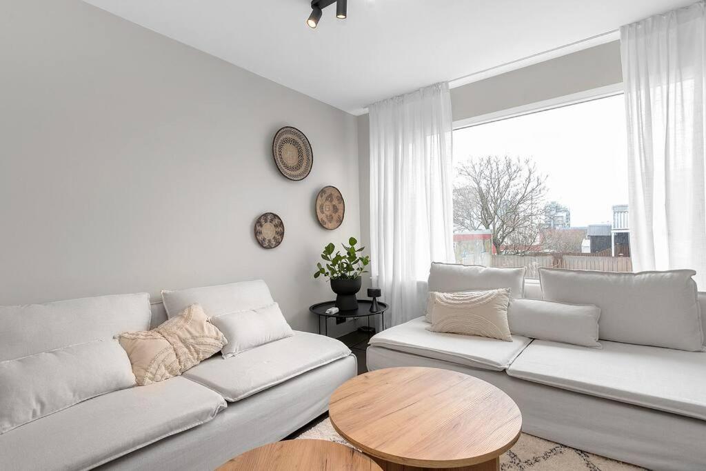 a living room with two white couches and a table at Cheerful 3BR Down Town Newly Renovated in Reykjavík