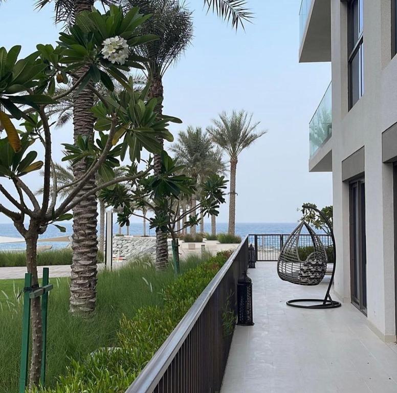 einen Balkon eines Gebäudes mit Palmen und Meerblick in der Unterkunft Address beach resort fujairah in Ḩaqīl