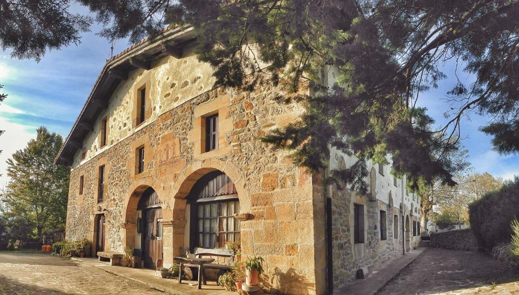 a stone building with a tree in front of it at Casa Rural Areano in Escoriaza