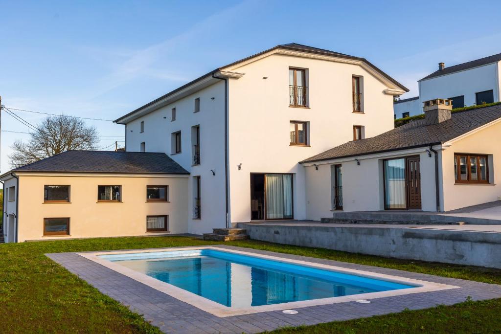 uma casa com uma piscina em frente em Casona del Campo em Navia