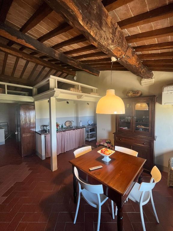 a kitchen and dining room with a wooden table and chairs at Appartamento centro storico La Pulcianella con vista in Montepulciano