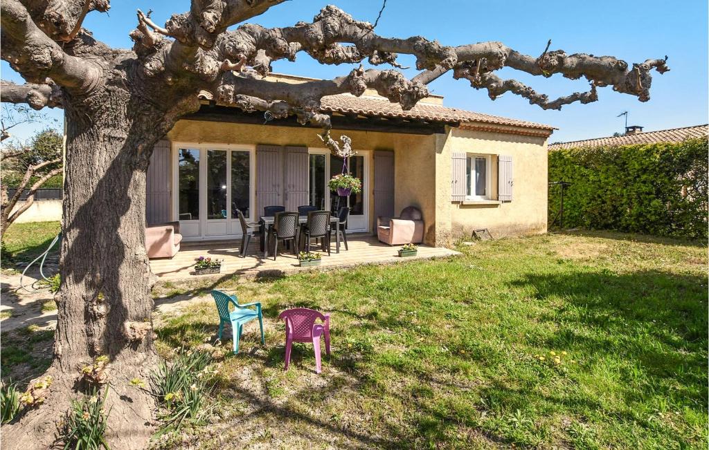 a house with chairs in the yard next to a tree at 3 Bedroom Pet Friendly Home In Rognonas in Rognonas