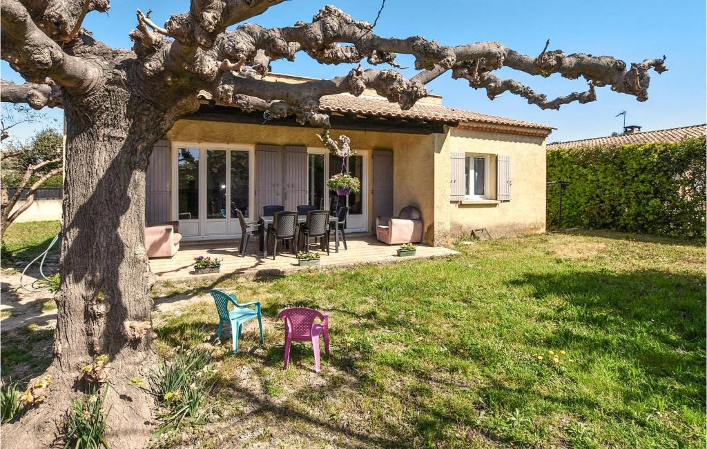 dom z krzesłami na podwórku obok drzewa w obiekcie Nice Home In Rognonas With Wifi w mieście Rognonas