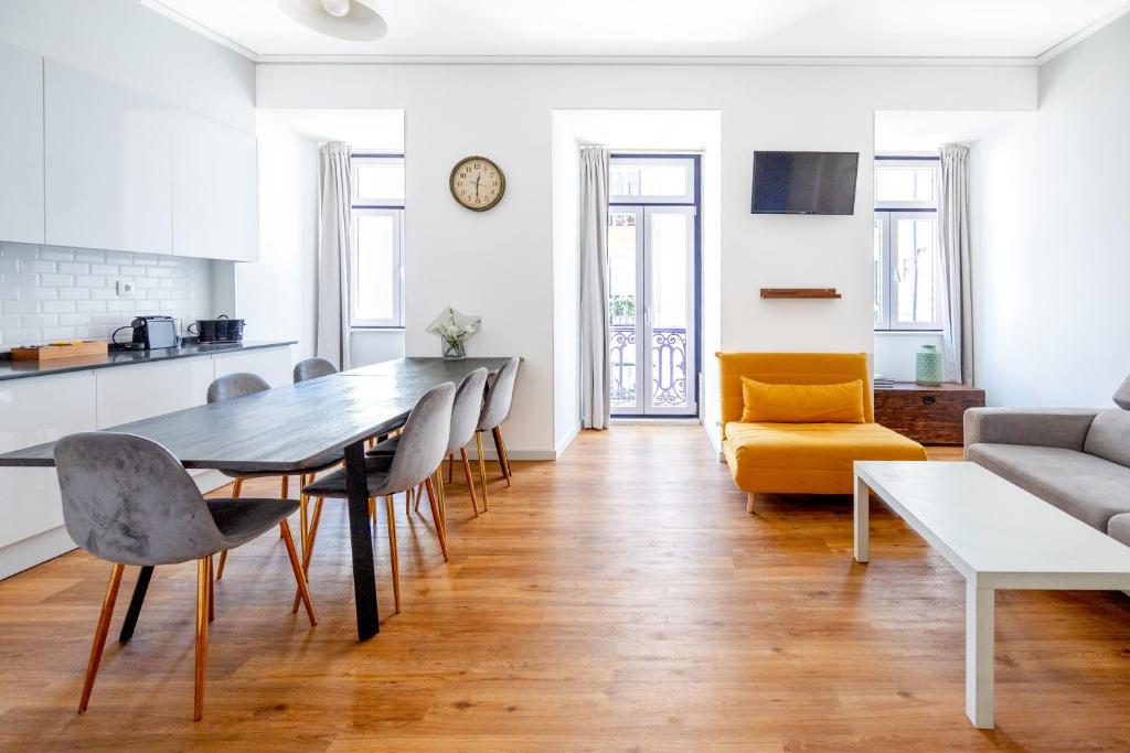 uma cozinha e sala de estar com mesa e cadeiras em Lisboa Intendente 3Bedroom Apartment with Balcony em Lisboa