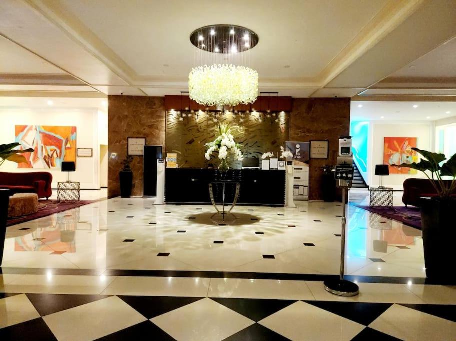 a lobby with a chandelier and a large room at Casa Antonio at Stamford McKinley Hill Unli Wi-Fi Near Piazza in Manila