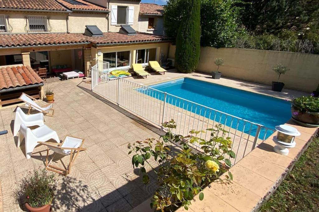 basen z dwoma krzesłami i dom w obiekcie Maison de famille (piscine, jacuzzi et sauna) w mieście Quillan