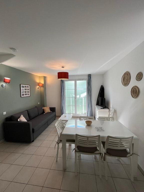 un salon avec une table et un canapé dans l'établissement Les Maisons du Golf de la Cabre d'Or by Ateya Vacances, à Cabriès