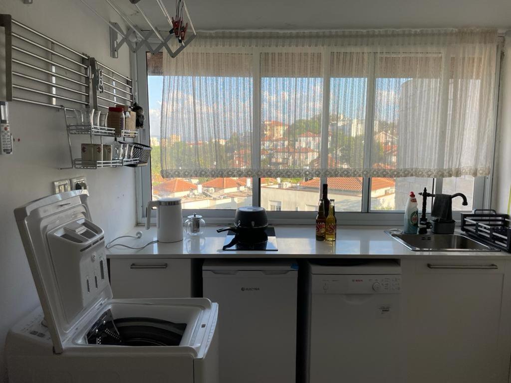 een keuken met een aanrecht, een wastafel en een raam bij my holiday apartment in Zikhron Ya‘aqov