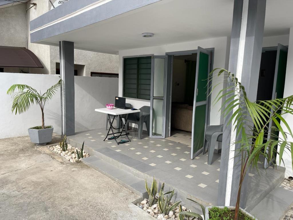 una casa con patio con mesa y escritorio en Villa meublée Cotonou fidjrosse 05 min de la plage, en Cotonou