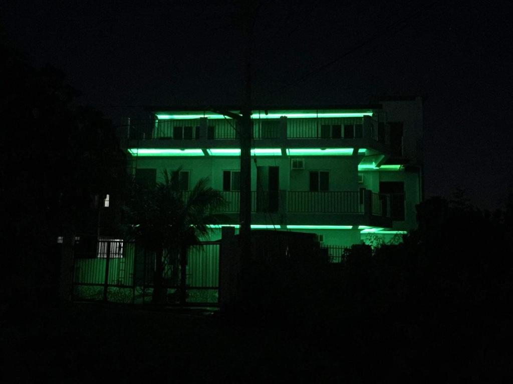 un edificio con luces verdes por la noche en White Sands Villas Maribago Lapu Lapu Cebu Tourist Area, en Maribago