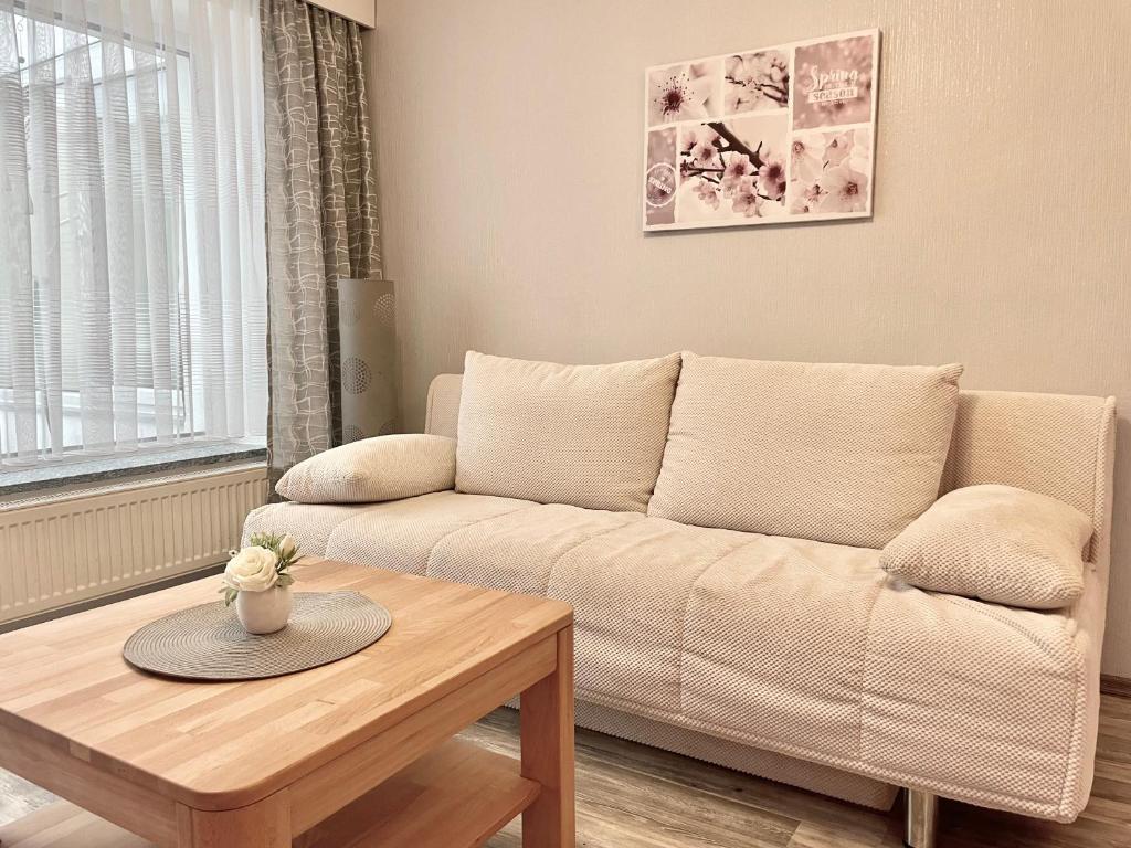 ein Wohnzimmer mit einem Sofa und einem Tisch in der Unterkunft Ferienwohnung Schwarzkollm in Hoyerswerda
