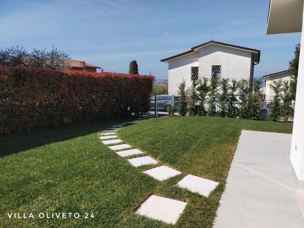 einen Garten mit Steppsteine im Gras in der Unterkunft Villa Oliveto 24 in Bardolino