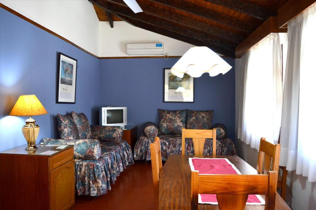 een woonkamer met een bank en een tafel bij POSADA NEHUEN in Villa General Belgrano