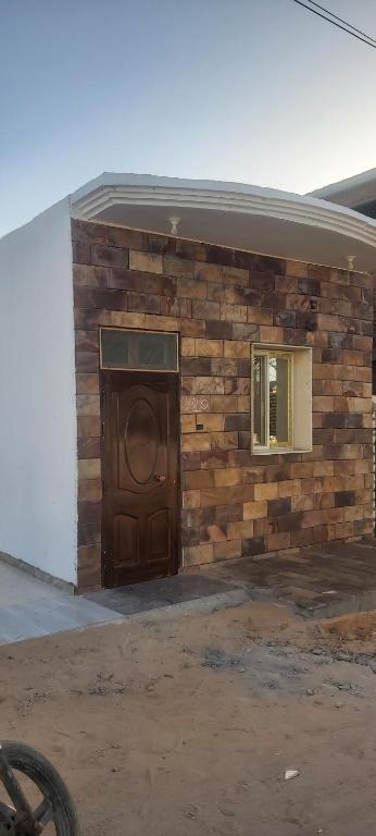 ein Holzgebäude mit einer Tür und einem Fenster in der Unterkunft Al fouad in Abu Simbel