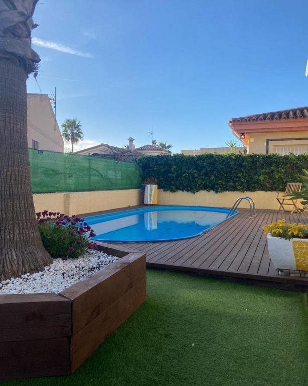 a backyard with a swimming pool and a wooden deck at MANDARINA in Riumar