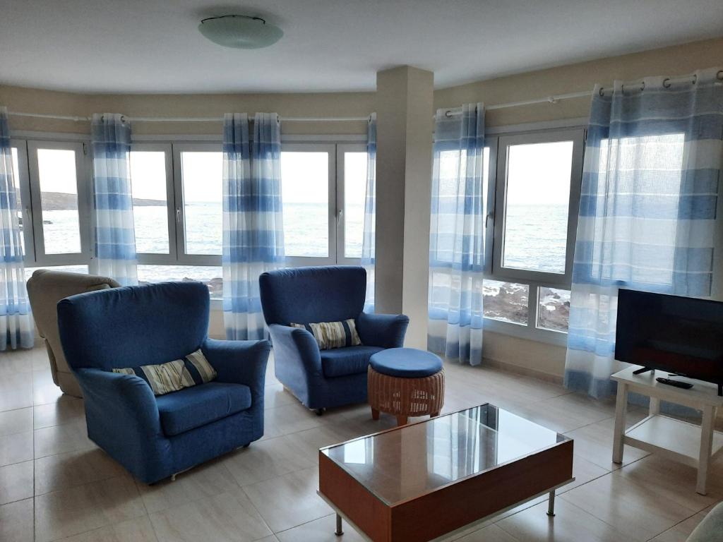 un soggiorno con 2 sedie e una TV di Crucero vista al mar A a Puertito de Güímar