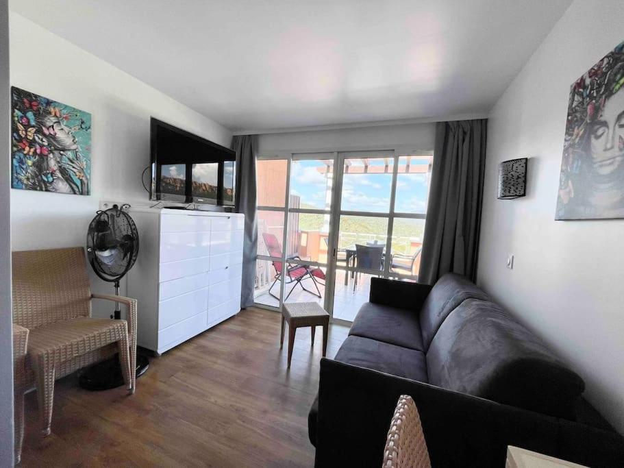 d'un salon avec un canapé et un balcon. dans l'établissement Appartement Cap Esterel 4/5 personnes, à Saint-Raphaël