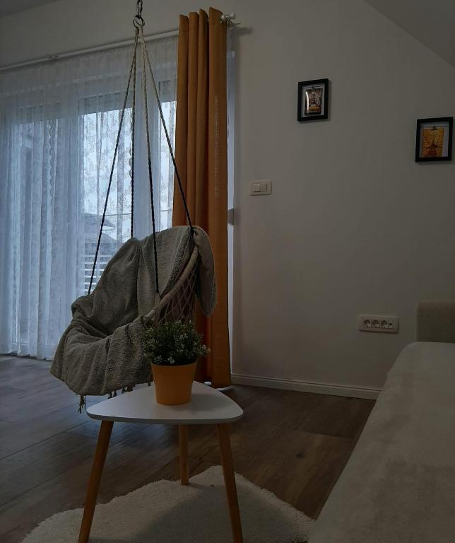a swing with a plant on a table in a living room at Elegant Inn Gospić in Gospić