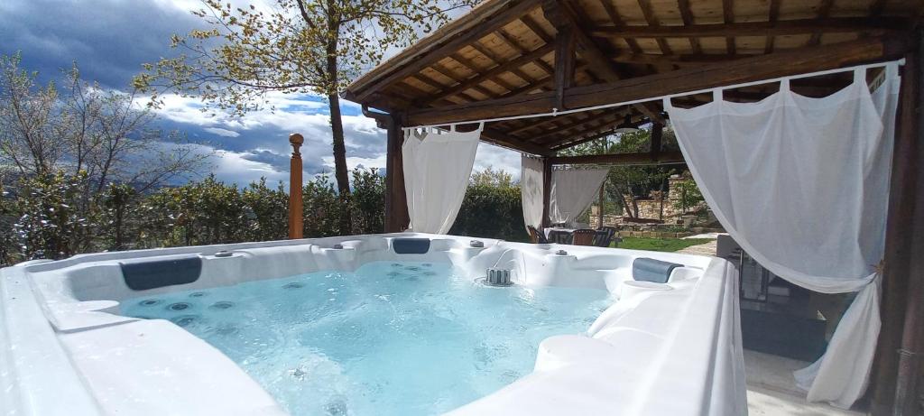 a large hot tub in a backyard with a roof at Domus Antiqua Bed & Breakfast in Spello
