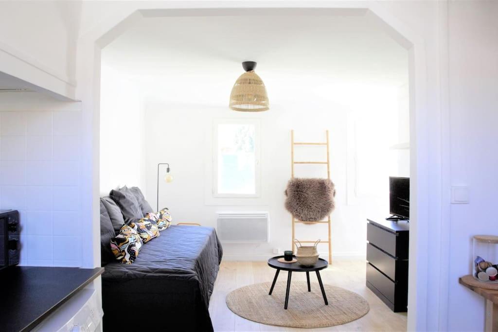 ein Wohnzimmer mit einem Sofa und einem Stuhl in der Unterkunft Le Nid - Au cœur du Cours Julien in Marseille