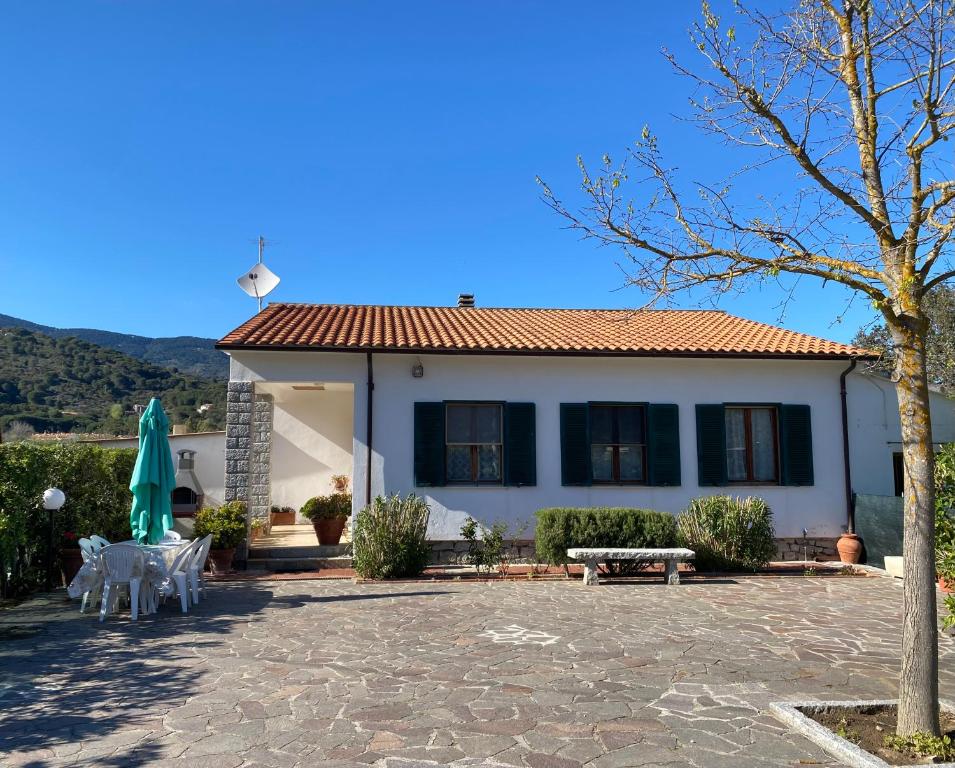 une maison avec une terrasse, une table et des chaises dans l'établissement Villa Antonia, à Marina di Campo