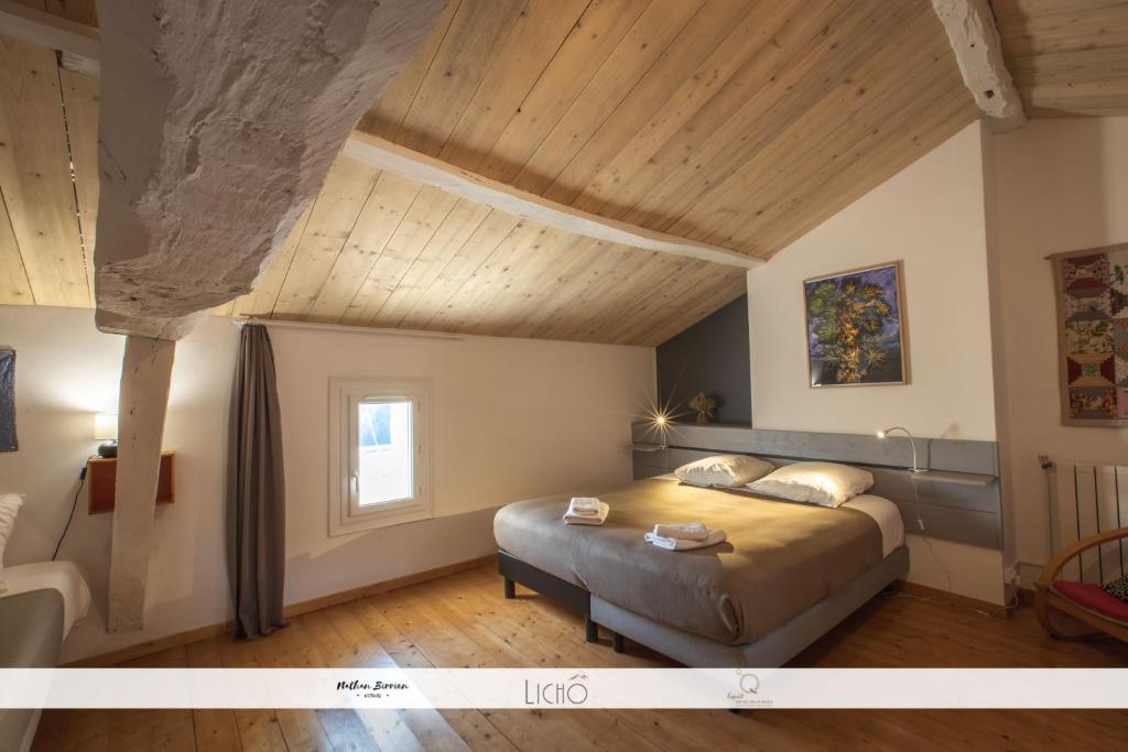 a bedroom with a bed and a wooden ceiling at Le Nid des Anges, votre studio à la campagne. in Saint-Laurent-du-Plan