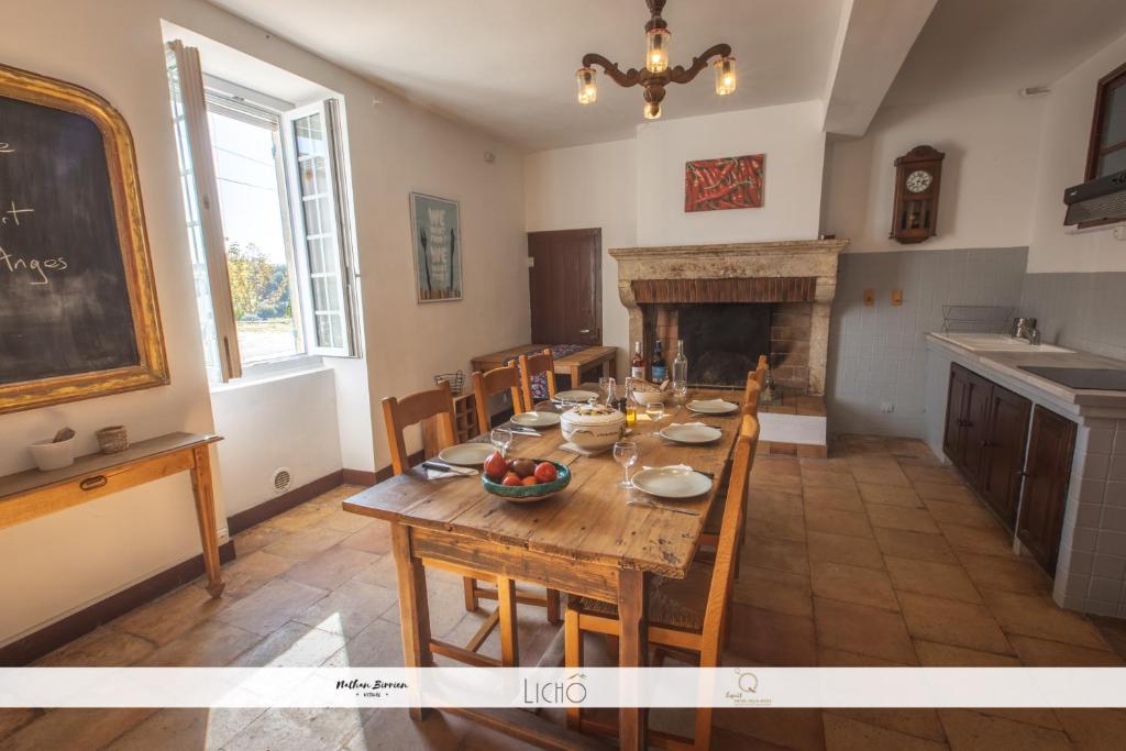 a dining room with a table and a fireplace at Le Nid des Anges, votre studio à la campagne. in Saint-Laurent-du-Plan
