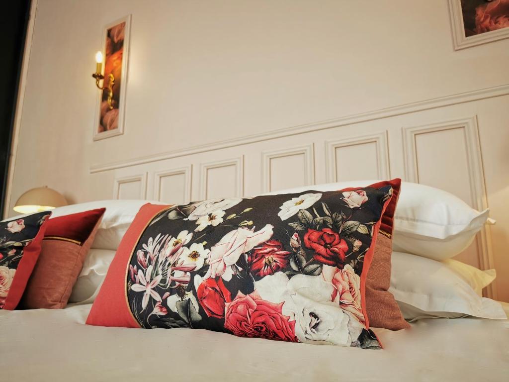 uma cama com uma almofada preta e vermelha em BELLE REINE - 3 APPARTEMENTS EN COEUR DE CENTRE-VILLE em Aix-les-Bains