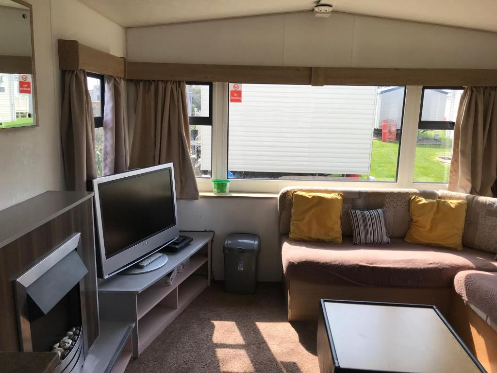 a small living room with a tv and a couch at Dotty at Seawick 106 in Jaywick Sands