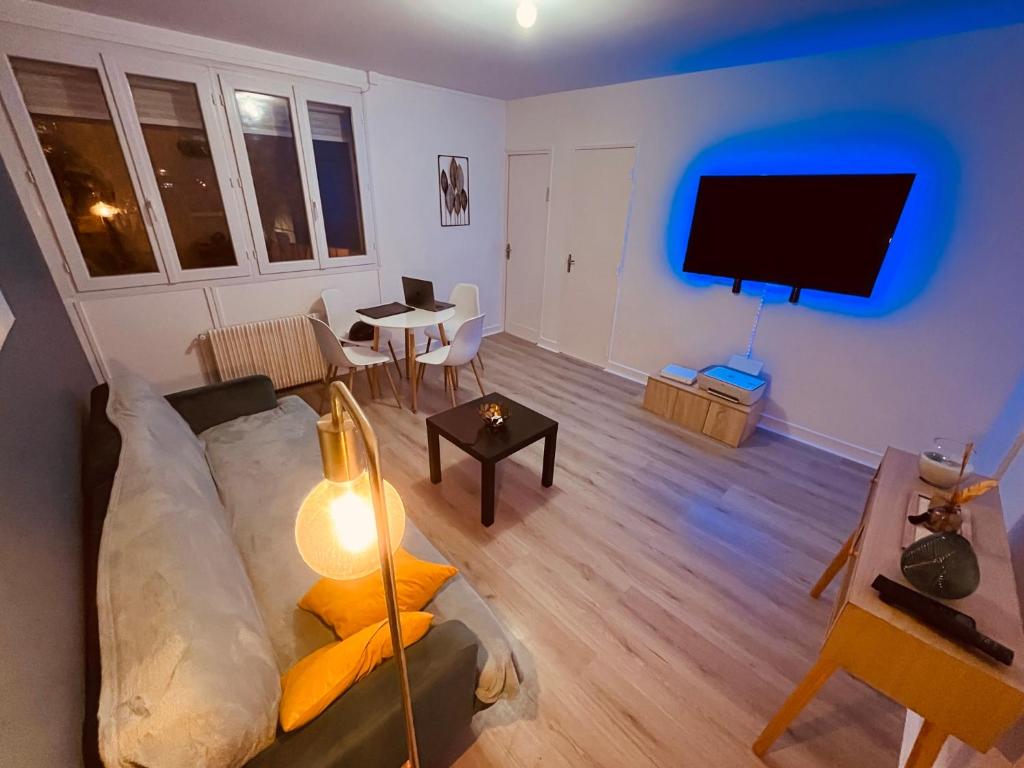 a living room with a couch and a flat screen tv at Appartement Prestige - Amiens in Amiens