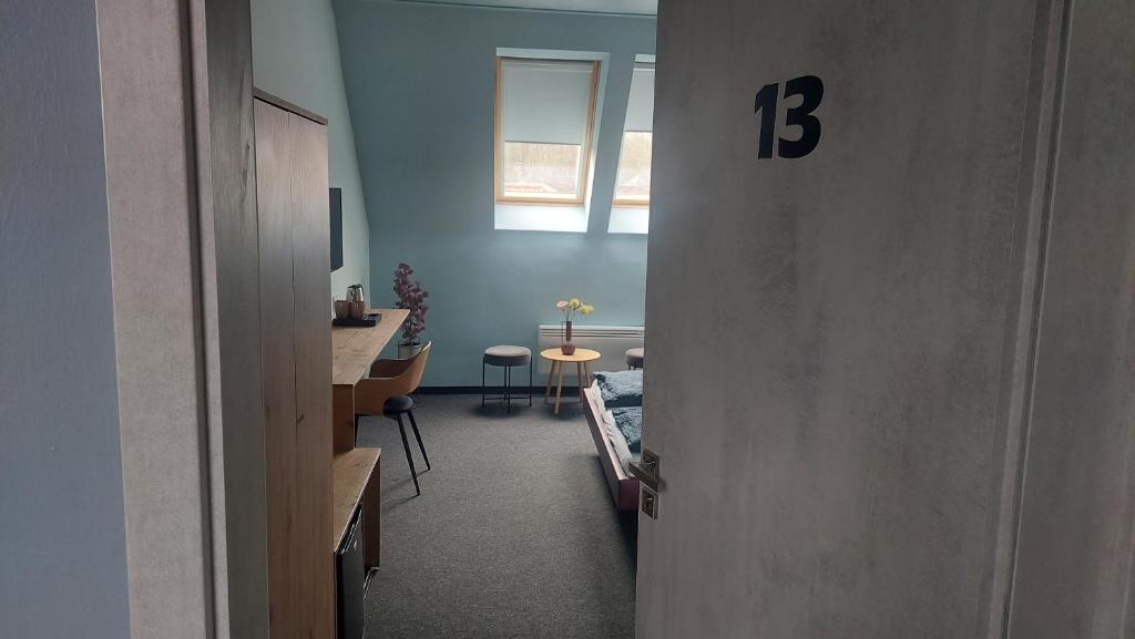 un pasillo con una habitación con una mesa y un número trece en Bornemisza Kúria Wellness Resort, en Tiszabecs