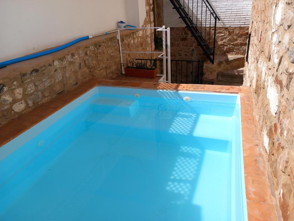 a swimming pool in a house with blue water at La Casa del Abuelo Curro in Baños de la Encina