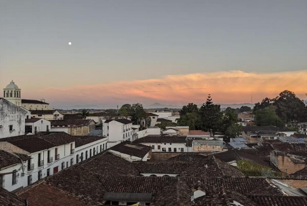 a view of a city at sunset with roofs at Habitación en penthouse en el centro histórico in Popayan
