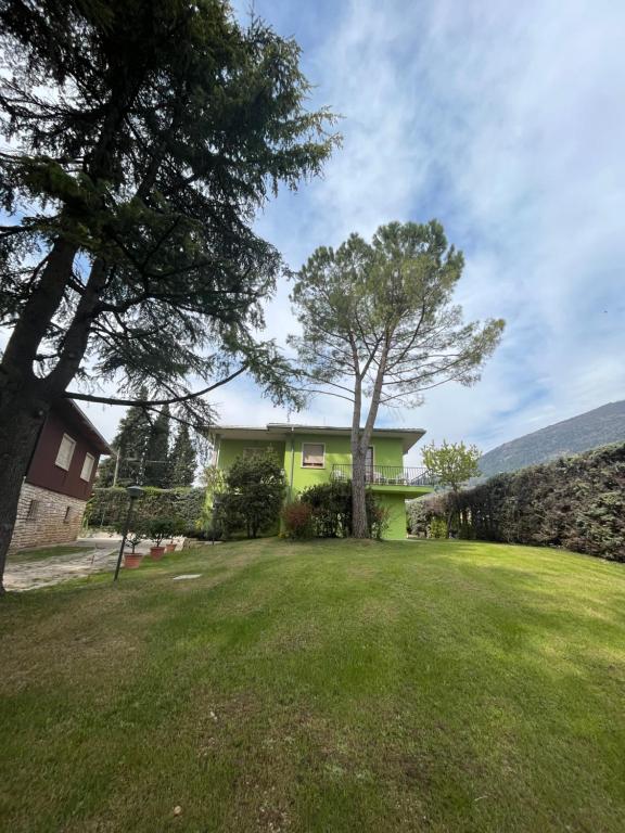 ein Haus mit einem Baum in der Mitte eines Gartens in der Unterkunft Secret Garden Egle in Caprino Veronese